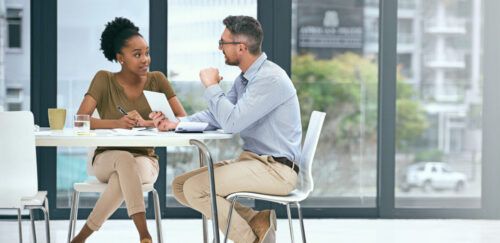 male and female talking at a table about careers services