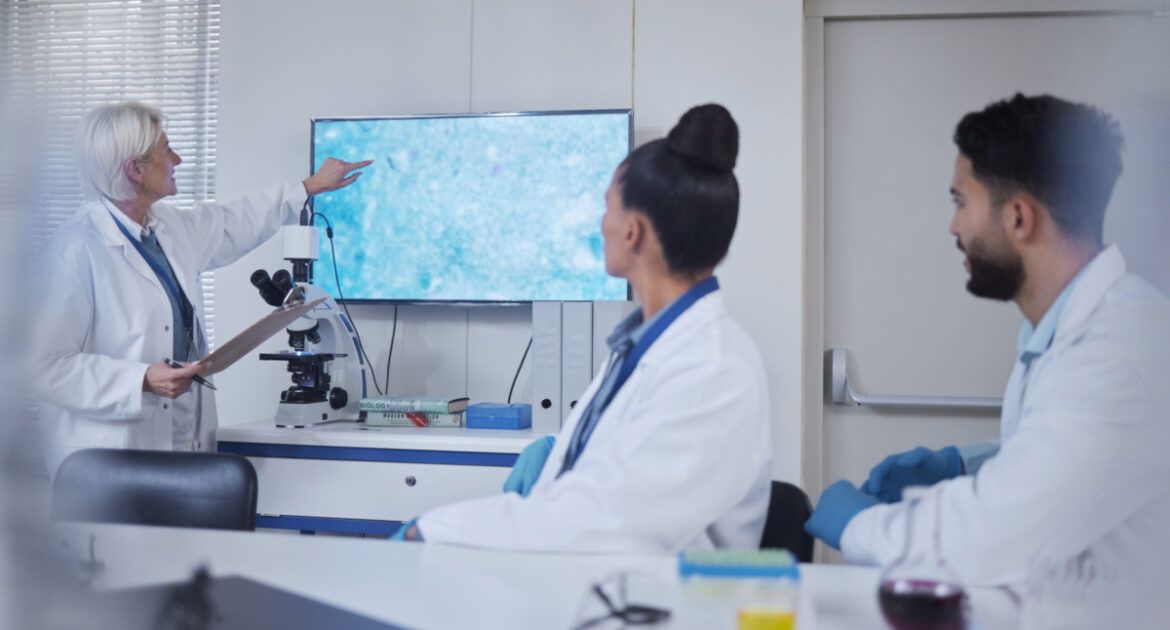 Presentation, science and scientist speaker in the laboratory meeting, training or seminar. Innovation, leadership and senior female researcher presenting discovery to her team with technology in lab