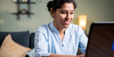 Young woman busy working on laptop at home