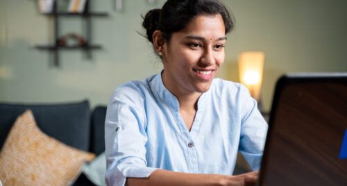 Young woman busy working on laptop at home