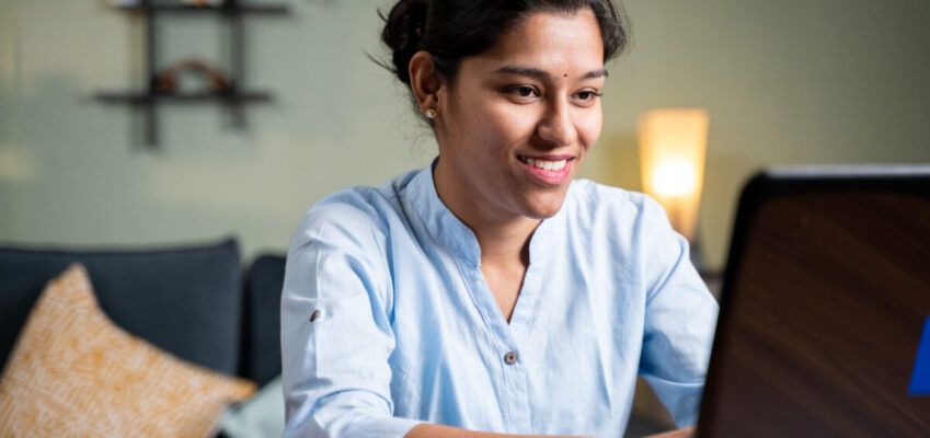 Young woman busy working on laptop at home