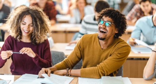 Cheerful black student having fun on a class in the classroom.