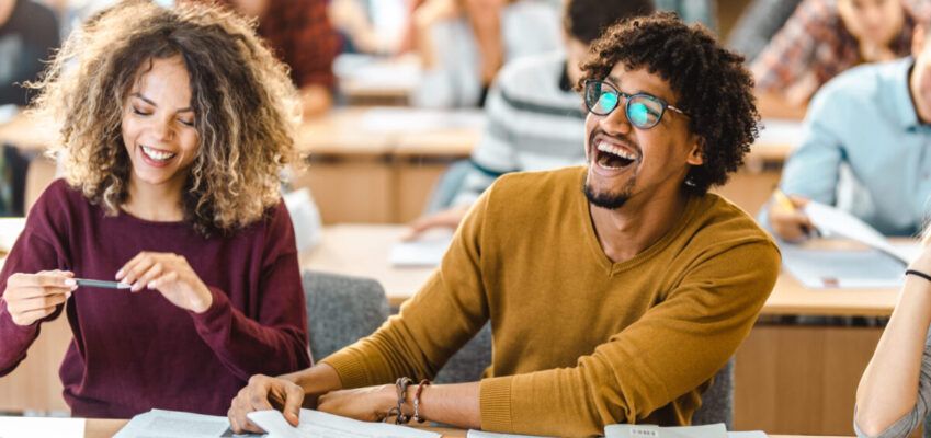 Cheerful black student having fun on a class in the classroom.