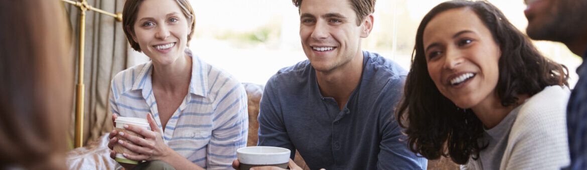 Colleagues relaxing around a table at a coffee shop, close up