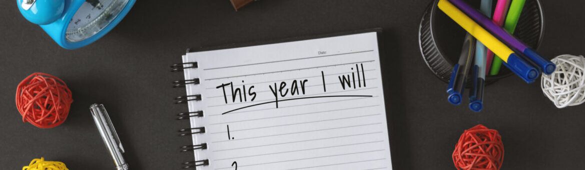 Notepad with wish list and coffee cup for new year.