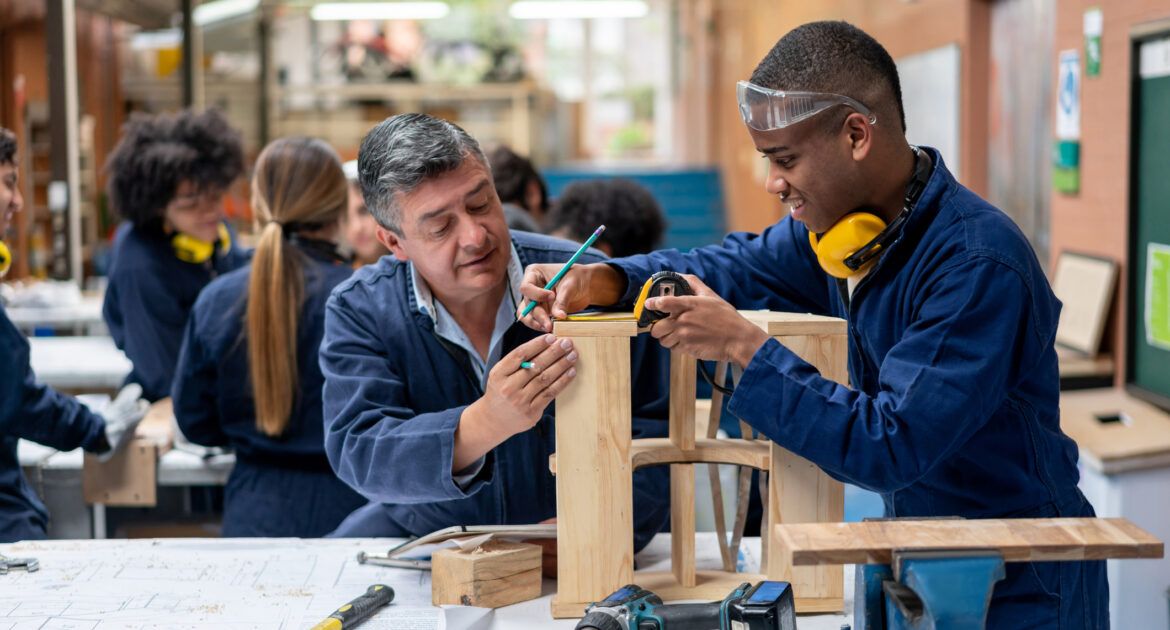 Industrial design student building furniture with the help of his teacher