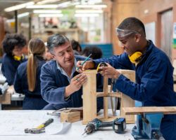 Industrial design student building furniture with the help of his teacher