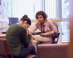 Female College Student Meeting With Campus Counselor Discussing Mental Health Issues