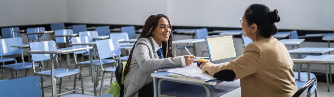 Teenager student getting feedback from a teacher in the classroom