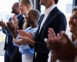 Diverse businesspeople smiling and clapping after a presentation in a boardroom