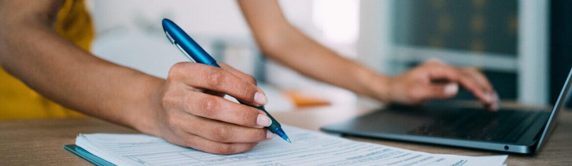 Woman on laptop and writing an application for a teaching job