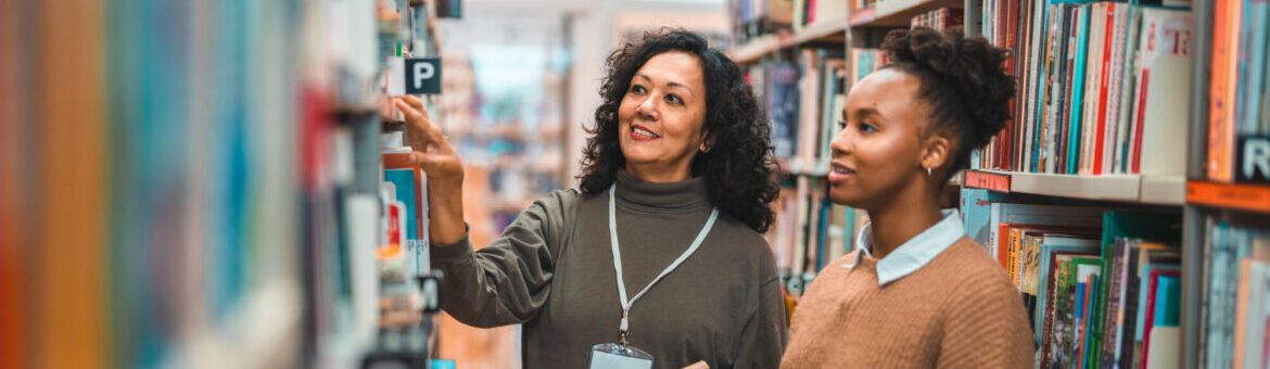 Adult Librarian Escorting A Student In A Library a non-teaching role