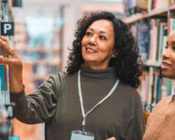 Adult Librarian Escorting A Student In A Library a non-teaching role