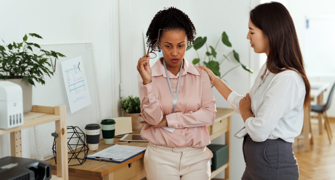 Businesswoman being consoled by her coworker at the office