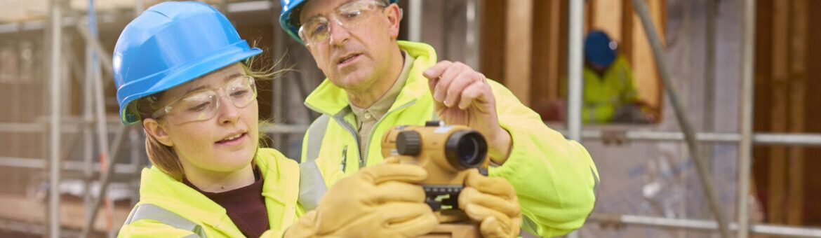 construction worker learning how to use a builder's level