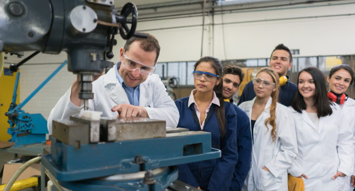 Teacher with a group of apprentices in an engineering class