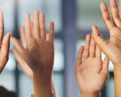 Hands raised in question to promote learning