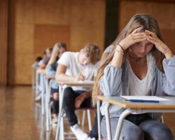 Anxious Teenage Student Sitting Examination In School Hall