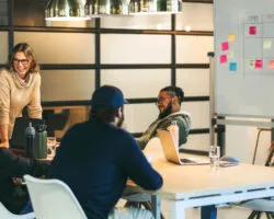 Successful teamwork in a diverse office: Colleagues smiling and talking in a productive meeting