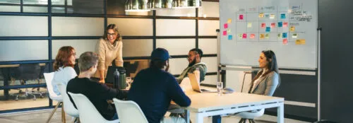 Successful teamwork in a diverse office: Colleagues smiling and talking in a productive meeting