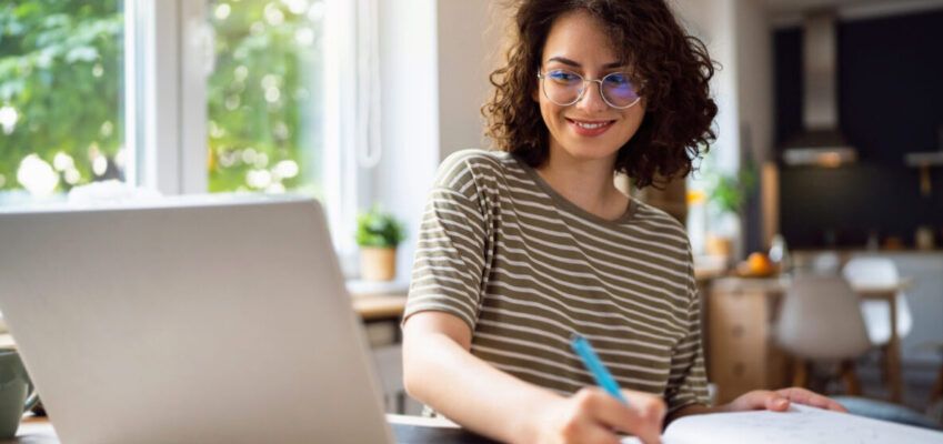 Young woman writing a Cover Letter for PhD Applications