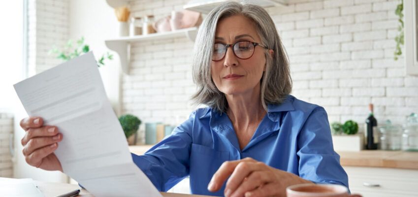 mature lady looking over paper work planning for retirement