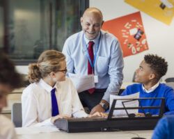 Male teacher interacting with group of students