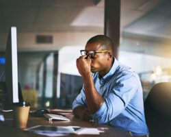 young man looking stressed at a desk