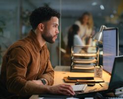 Office, night and businessman with computer for research, online information and solution for startup. Screen, male employee or digital marketing specialist with laptop for seo, keywords or web tools