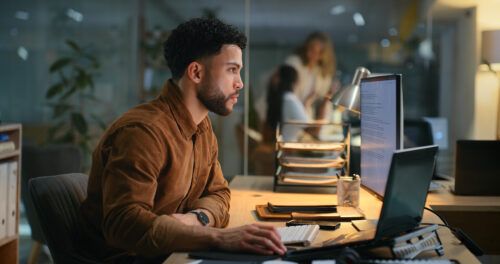 Office, night and businessman with computer for research, online information and solution for startup. Screen, male employee or digital marketing specialist with laptop for seo, keywords or web tools