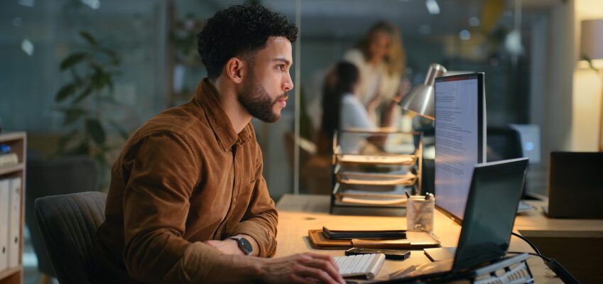 Office, night and businessman with computer for research, online information and solution for startup. Screen, male employee or digital marketing specialist with laptop for seo, keywords or web tools