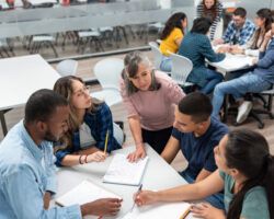 Teacher in class explaining something to a group of students