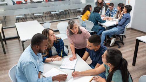 Teacher in class explaining something to a group of students