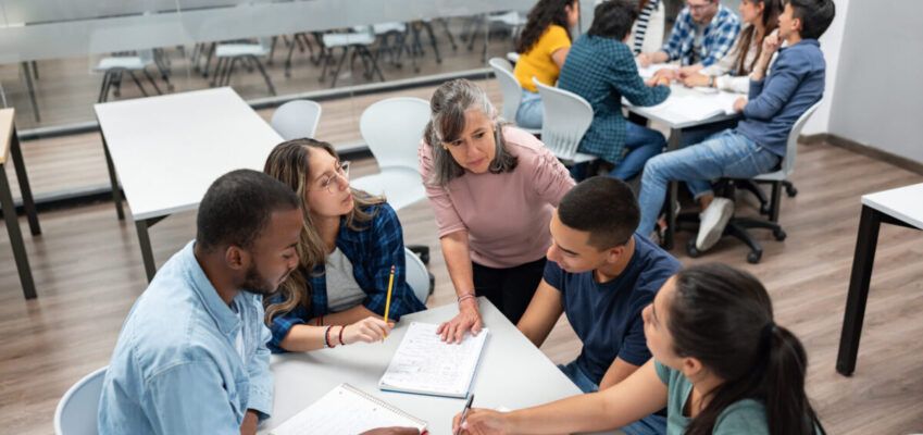 Teacher in class explaining something to a group of students