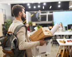 young man leaving office after being made redundant