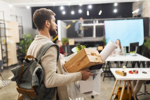 young man leaving office after being made redundant