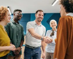 group of people shaking hands to welcome new colleague